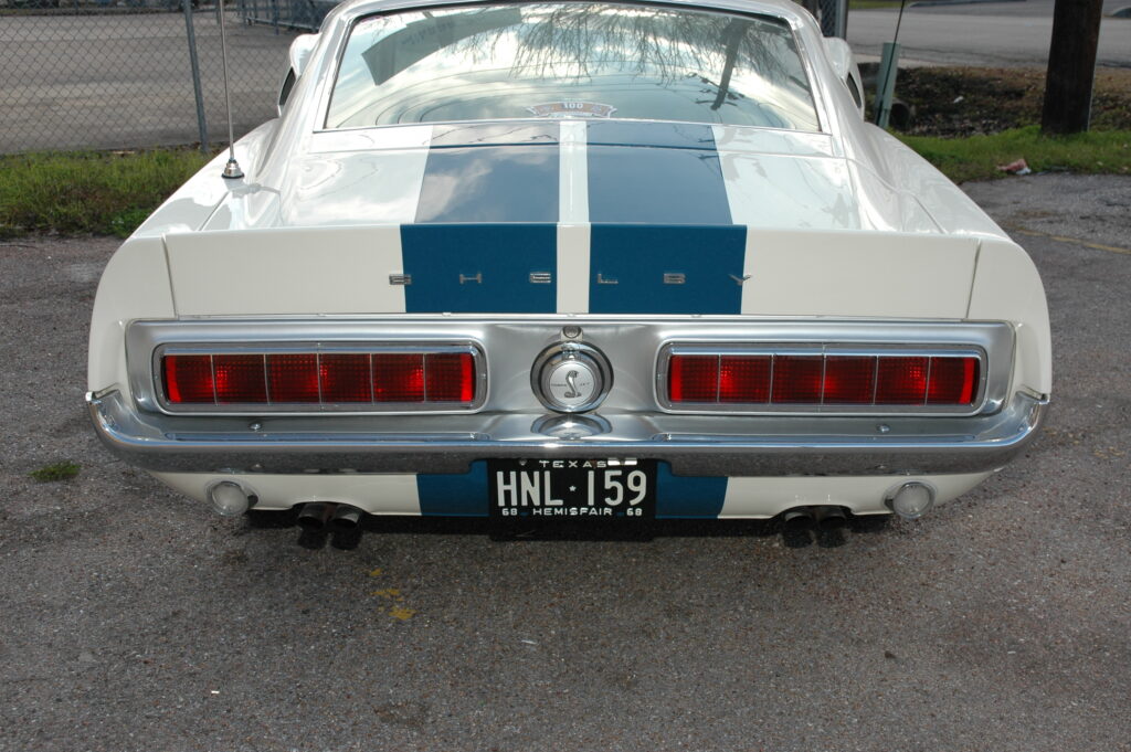 Rear view of a white Shelby Mustang with blue stripes